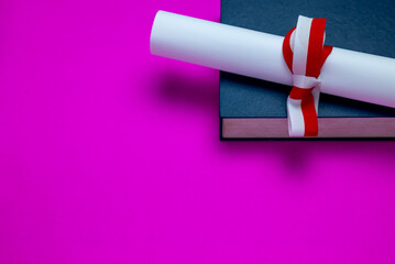 Books and diplomas with red ribbon
