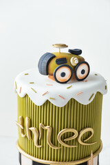 Beautiful tall two-tiered fondant cake on white background. Birthday steampunk style cake for...