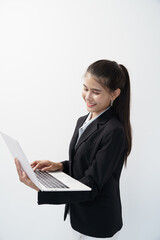 Portrait of Asian businesswoman standing holding and using laptop in white studio background