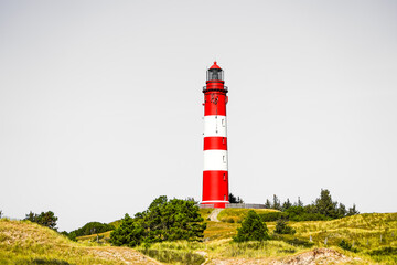 View of the dunes on the North Frisian island of Amrum. Landscape in the north. Nature on the North Sea island with a lighthouse.
