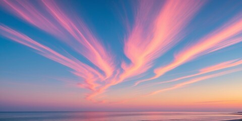 Fototapeta premium Colorful clouds appear in the sky during a serene dusk near a coastal area