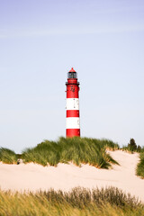 View of the dunes on the North Frisian island of Amrum. Landscape in the north. Nature on the North Sea island with a lighthouse.