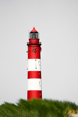 View of the red and white lighthouse on the North Frisian island of Amrum.
