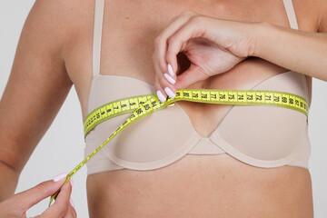 girl measuring her breast size, concept of increasing breast size and shape,