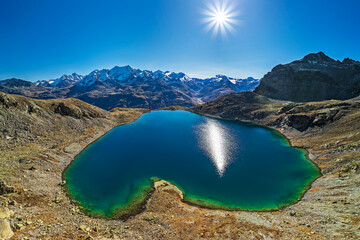 Aerial view of Lej da la Tscheppa lake amidst Albula Alps under blue sky at sunny day