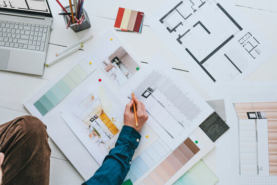Hand of interior designer making project with pencil at office