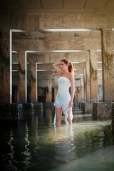 Woman in white dress under concrete structure