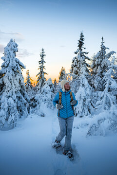 Woman walking in snowy forest  in national park of Finland