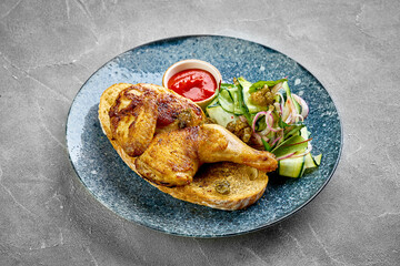 A close-up of a grilled chicken leg, showcasing the crispy skin and juicy meat. The dish is served with a fresh salad, creating a delightful contrast of textures.