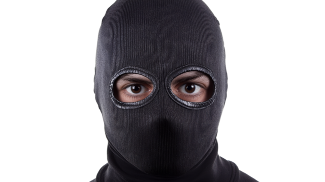 Criminal wearing balaclava looking at camera on transparent background