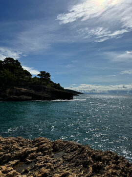 Sea bay blue shiny waters and rocky coastline. 
