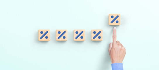 Hand choosing increasing percent on wooden cube, Interest rate financial, mortgage rates, profit concept