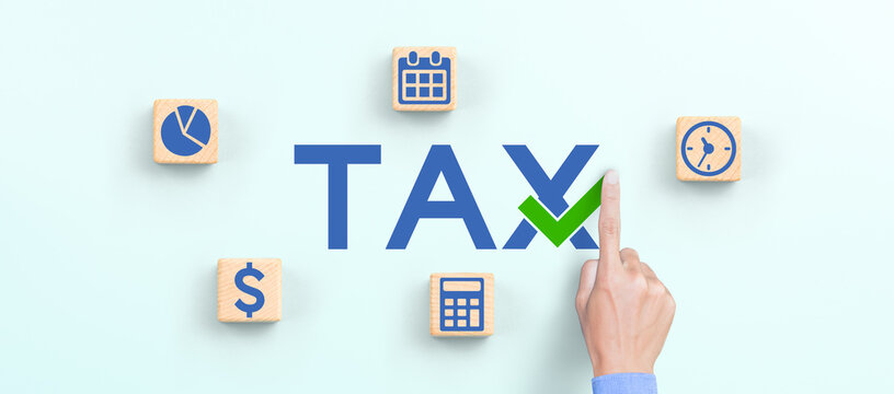 Businessman hand and TAX icons on wooden cubes. Tax reduction planning, tax time