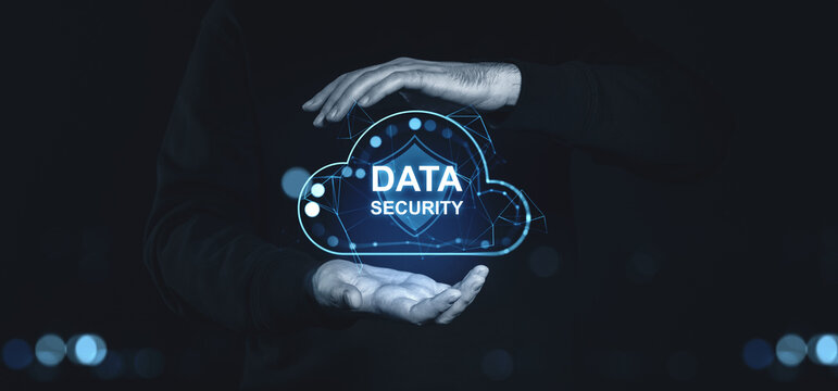 Hands holding holographic cloud with "Data Security" text and shield on dark background. - Powered by Adobe