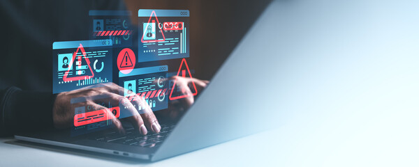 Cybersecurity warning icons over hands typing on laptop keyboard.