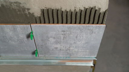 Laying ceramic tiles on the wall using tile leveling system