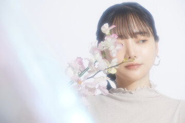 Fototapeta premium 光と影の背景で撮影をした若い女性の爽やかなビューティーポートレート