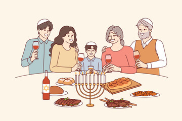Jewish family at festive table with minor, drinks red wine and eats traditional food. Jewish religious holiday is celebrated by israeli residents of different generations and ages.