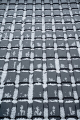 This closeup photograph showcases a rooftop blanketed in pristine white snow, creating a...