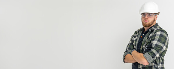 Portrait of a male builder. Engineer in overalls and helmet on a light background. Space for text.