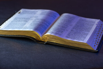Obraz premium Open Holy Bible on the table. Religion concept. Bible on black background.