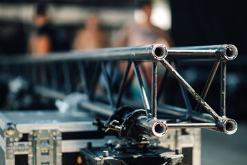 Metal truss structure lying on flight case being assembled for concert