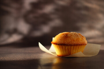 Dessert small cupcake on parchment on dark background
