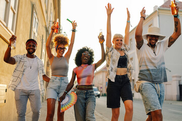 Young people raising arms and celebrating at a summer music festival