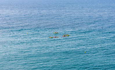 several people kayaking in the middle of the ocean