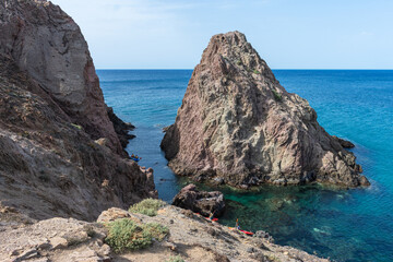 adventurous kayakers crossing between the rocks of the sea shore