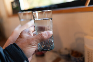 コップに注がれた水を持っている人	