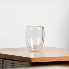 Empty glass of water on a wood table with clear reflections.