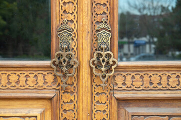 New double leaf carved door with metal decorative handles closeup in Uzbekistan, Asia