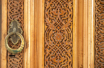 New carved wooden door with metal decorative handle closeup in Uzbekistan, Asia