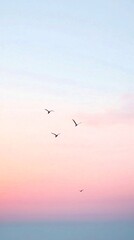 Obraz premium Graceful Birds in Flight Against a Dreamy Pink and Purple Sunset Sky, Minimalist Nature Photography Phone Wallpaper in 4K Ultra HD