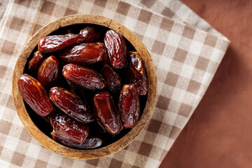 Dried Dates in Wooden Bowl on Beige Checkered Napkin