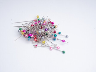 colorful pins on ring magnet isolated white background,pins are used to mark a point or as a tool for making crafts,It is made of stainless with a pointed end. Pins are usually used to hook