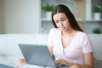 Suspicious woman using laptop in a house