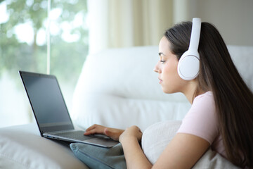 Woman using laptop listening audio
