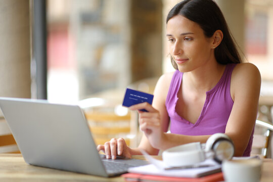 Student buying online in a bar terrace