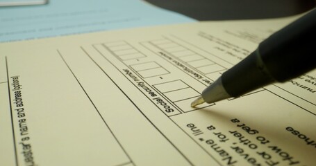 A person fills out a taxpayer's form. Close-up of a pen, an unrecognizable person