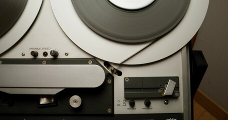 Obraz premium Sound recording on a tape recorder in a recording studio. Fast movement of the magnetic tape, close-up