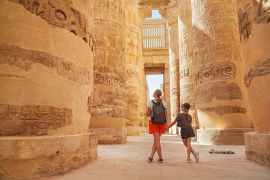  Egypt - karnak hypostyle hall columns in the temple at luxor thebes and happy tourist girls - mother and daughter on vacation.