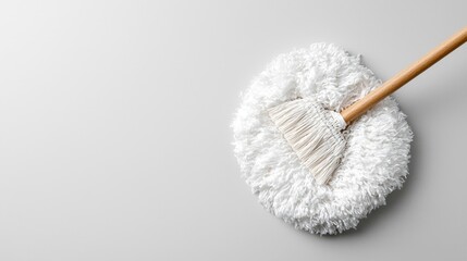 Cleaning mop on white surface, minimalist background, cleaning supplies