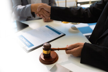 Lawyer shaking hands with client after discussing final contract agreement