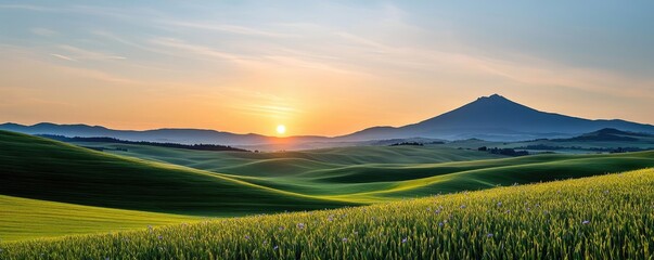 Mountain peak nature idea. Breathtaking sunset view over lush green hills and a majestic mountain in the distance.