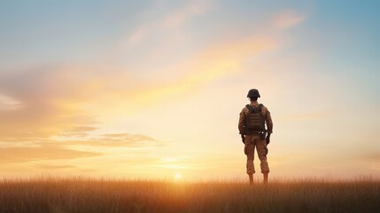 Fototapeta premium A soldier stands in a field at sunset
