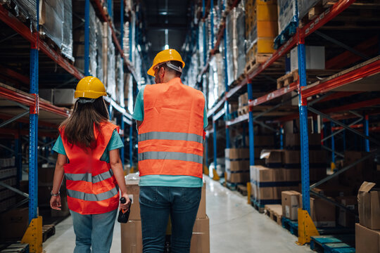Warehouse workers walking through large distribution center