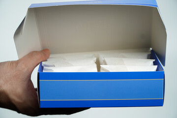 Human hands hold snacks in a cardboard box. Beautifully organized charcuterie box