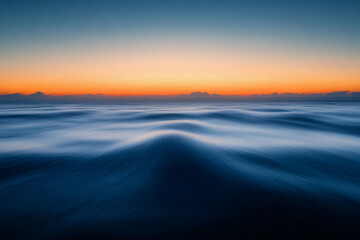 Fototapeta premium Sunset over calm ocean waters creates a serene atmosphere with vibrant colors on the horizon